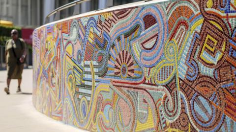 The new mosaic outside London Bridge Station, with someone in the background about to walk past