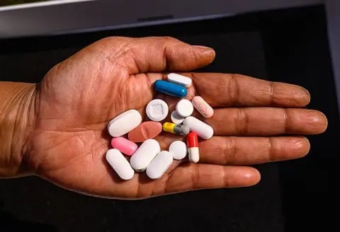 Getty Images A hand holding pills