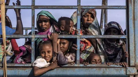 AFP Sudanese refugees and South Sudanese returnees who have fled from the war in Sudan stand on a truck arriving at a Transit Centre for refugees in Renk, on February 13, 2024