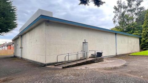 The large, windowless, concrete structure Sits among residential houses in south Belfast