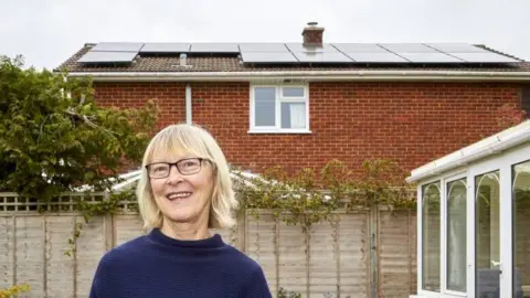 A woman standing in front of her house