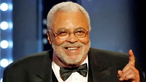 James Earl Jones smiling on stage as he received a special Tony Award in 2017. He is wearing a tuxedo.