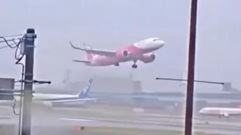 Red and white plane starts to rise after aborting landing on airport runway