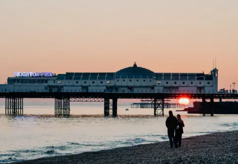 Brighton Pier with the sun setting below it