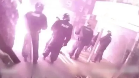 A firework explodes in front of police wearing riot gear