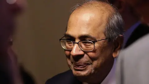 Getty Images Prakash Hinduja, wearing glasses and listening intently at World Economic Forum (WEF) in Davos years before he was jailed for mistreatment of workers