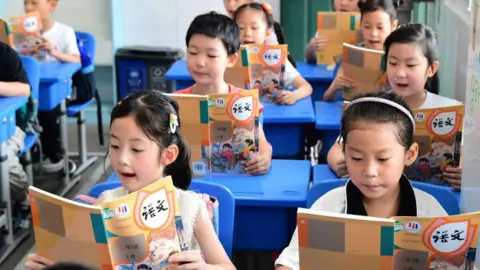 Primary school students read textbooks in the classroom as new semester in Hefei, Anhui