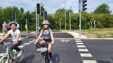 Two teenage girls cycling over a newly installed crossing on Kidlington Roundabout.