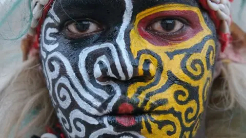 "A performer poses in a traditional Simb costume during a cultural show in Senegal"