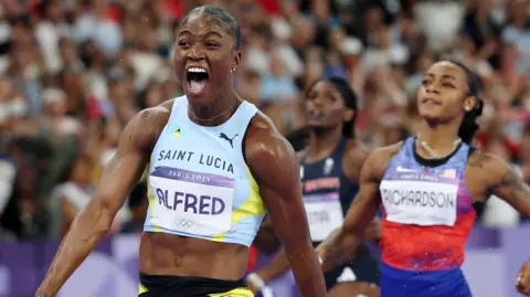 Julien Alfred celebrates winning Olympic 100m gold