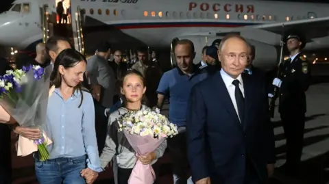 Russian President Vladimir Putin (R) meets Russian citizens released after the Russian-US prisoner swap in Turkiye at Vnukovo International Airport in Moscow, Russia, 01 August 2024.