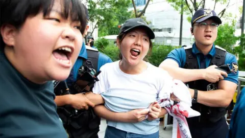 EPA Police officials detain university student protesters as they try to enter the Japanese embassy amid a rally in Seoul, South Korea, 24 August 2023