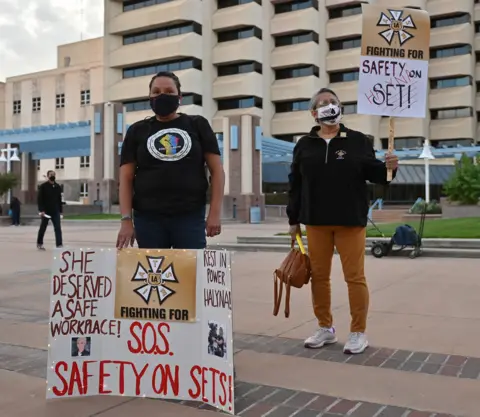 Sam Wasson Vigil for Halyna Hutchins with people holding up placards calling for "safety on set"