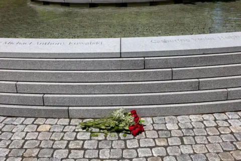 A bouquet of flowers next to a stone fountain, a memorial to the victims of the Sandy Hook Elementary School shooting