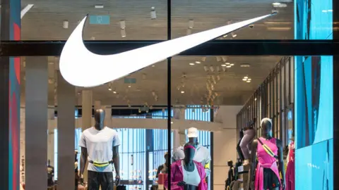 Nike shop front displaying large white tick and mannequins