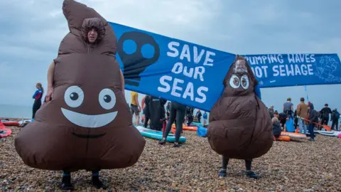 Getty Images Sewage protests on a beach in East Sussex