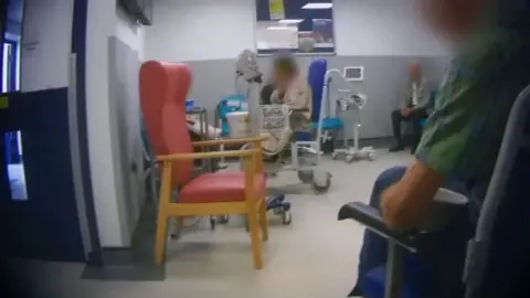 A hospital waiting room with three people 