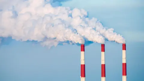 Red and white striped chimneys with white smoke coming out of the top.