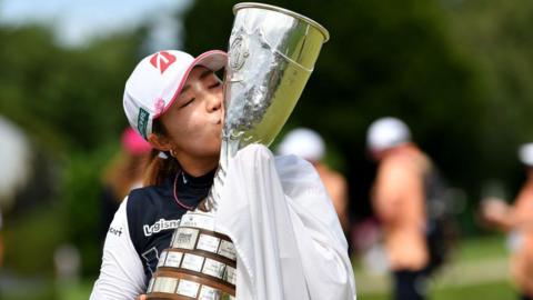 Ayaka Furue kisses the Evian Championship trophy after winning her first major