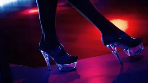 A woman's feet shown in high heels on a dancefloor 