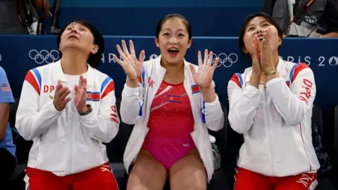 Reuters Flanked by two coaches, An Chang-ok waves for the camera