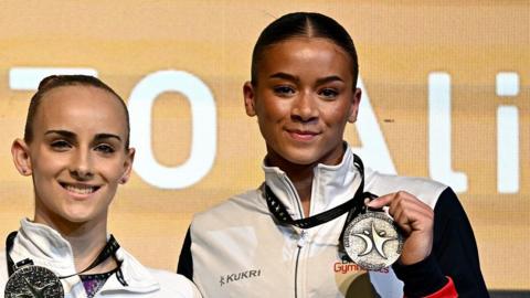 Britain's Georgia-Mae Fenton, right, with her bronze medal after finishing third in the uneven bars at the Gymnastics European Women's Championships in Rimini, Italy