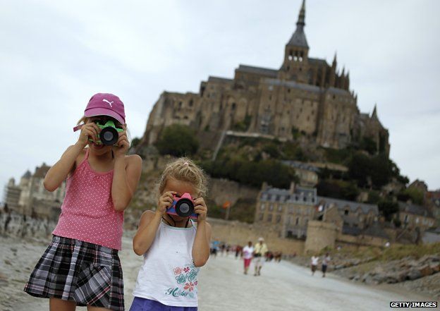 Two girls take photos at Mont-Saint-Michel