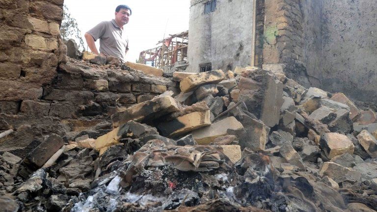 In this 25 April 2013 photo, a man stands amid the site of a violent clash in Kashgar, in China’s northwestern region of Xinjiang