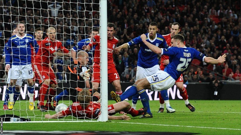 Cardiff City's Ben Turner (second right) shoots to score against Liverpool