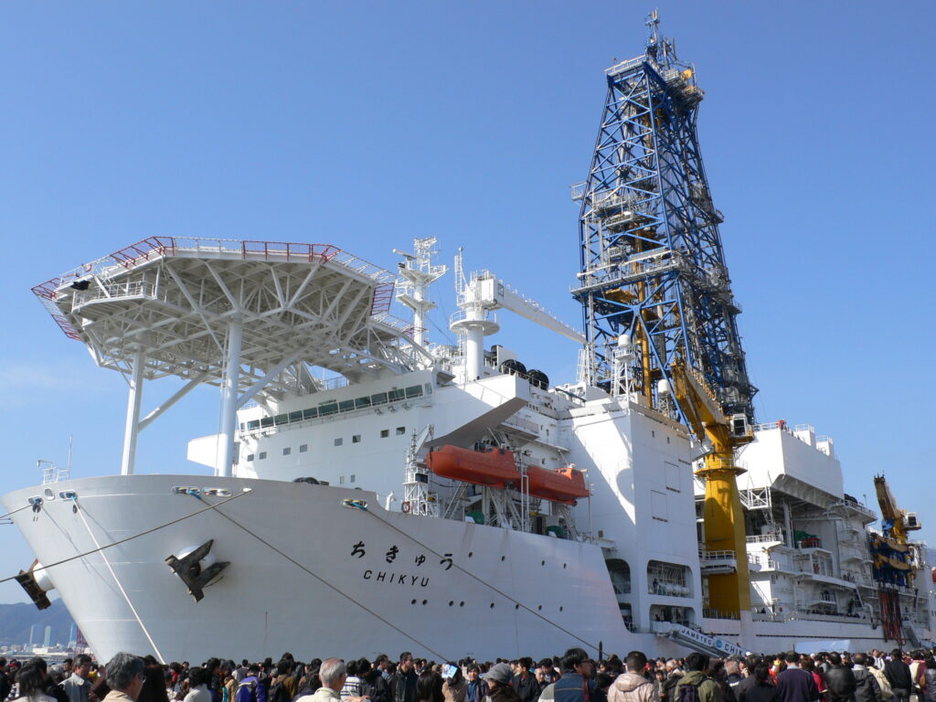 A crowd has gathered around the docked boat.