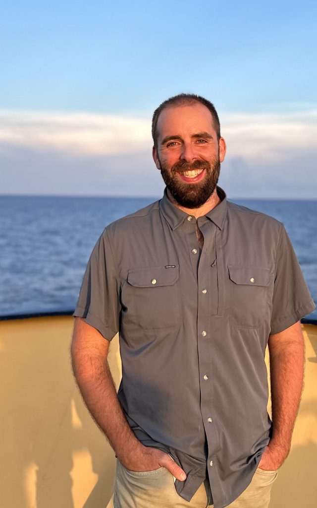 Portrait photo of Chris on the deck of a ship