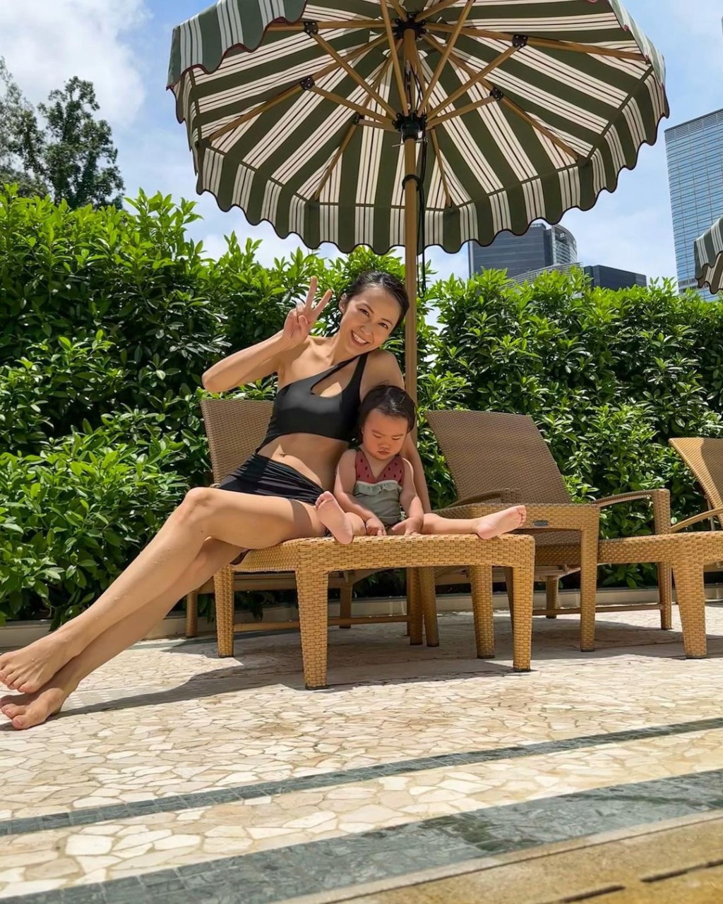 可見她與女兒「麥QQ」坐在泳池旁，湯怡笑容滿面，但女兒「麥QQ」卻做出厭世樣。