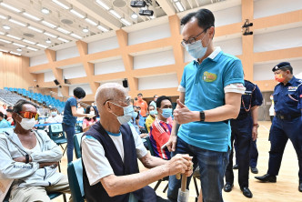 聶德權（前排右）在西貢賽馬會大會堂與一名91歲長者（前排左）交談。政府新聞處