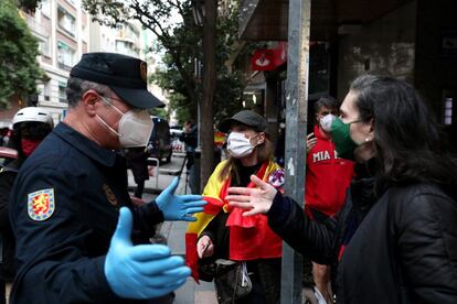 Un agente de Policía Nacional se dirige a unas manifestantes.