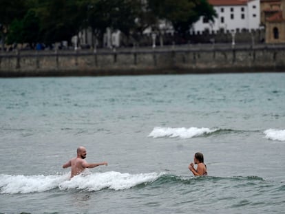 Dos aguerridos bañistas en la playa de San Lorenzo de Gijón, este domingo.