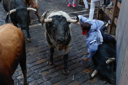 Un mozo es arrollado por uno de los toros de la ganadería de Cebada Gago en la curva de Mercaderes, este lunes durante el segundo encierro de los Sanfermines.