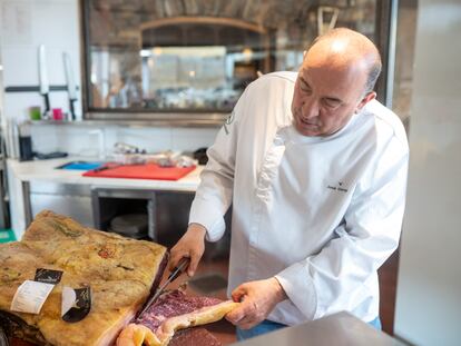 José Gordón corta una chuleta de buey, en la cocina de El Capricho.