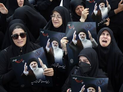 Unas mujeres iraníes sostienen carteles con la imagen de Ebrahim Raisí, en una ceremonia de luto en Teherán este lunes.