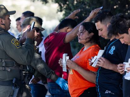 Un miembro de la Policía Fronteriza toma fotografías de inmigrantes con sus documentos de identidad en Jacumba Hot Spings (California), el 26 de mayo.