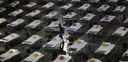 Un trabajador rocía desinfectante en camas en un hospital especial temporal para pacientes con Covid-19 en Bombay (India).