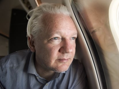 Julian Assange mira por la ventanilla del avión en los alrededores del aeropuerto de Bangkok, este martes.