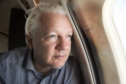 Julian Assange mira por la ventanilla del avión en los alrededores del  aeropuerto de Bangkok, este martes.