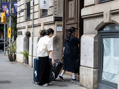 Dos viajeras entran en un piso turístico en el centro de Barcelona.