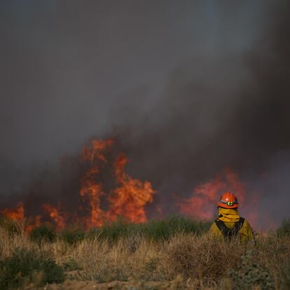 Un bombero observa el fuego en Lancaster, California, el 16 de junio 2024.