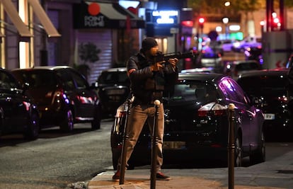 Un oficial de policía sostiene un rifle de asalto cerca del sitio de un tiroteo en los Campos Elíseos en París.