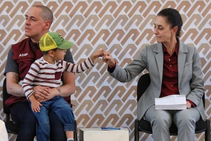 José Antonio Peña Merino sostiene a su hijo junto a Claudia Sheinbaum durante un evento oficial en la alcaldía Iztacalco, en septiembre de 2022.  