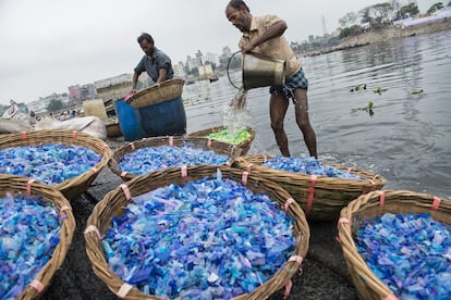 Un grupo de hombres lava plástico para su reciclaje en el Buriganga.