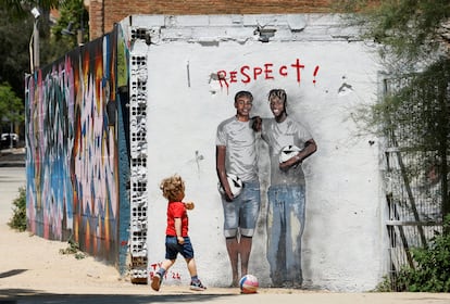 Un niño juega en Barcelona ante un mural de Lamine Yamal y Nico Williams.