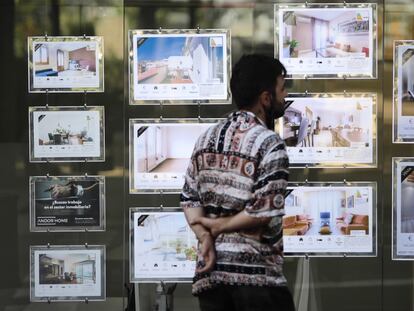 En la imagen un joven mira anuncios de alquiler de una inmobiliaria en Barcelona.