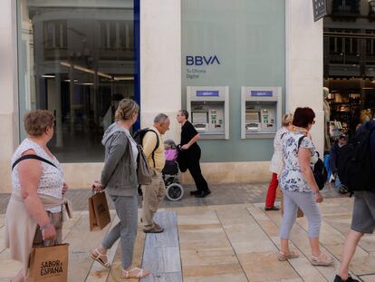 Varios ciudadanos pasan ante una sucursal del BBVA en Málaga.